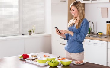 Poland: In the kitchen, smartphone in hand
