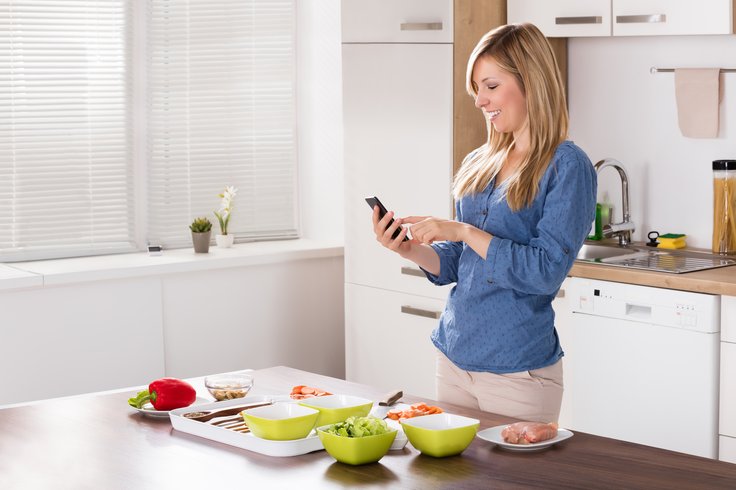 Poland: In the kitchen, smartphone in hand